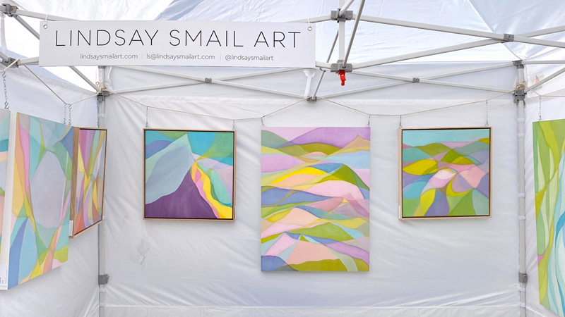 Abstract paintings hanging in a white tent